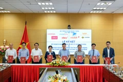 Representatives of Vietnamese mobile network operators – Viettel, VNPT, MobiFone, Vietnammobile, Local, Reddi, Itel, and GMobile – sign an agreement to fight spam calls jointly. (Photo: VietnamPlus)