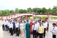 Vietnamese in Laos offer incense and flowers to President Ho Chi Minh. (Photo: VNA)