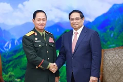 Prime Minister Pham Minh Chinh (R) receives Lao Defence Minister Sen. Lieut. Gen. Khamliang Outhakaysone in Hanoi on December 18. (Photo: VNA)