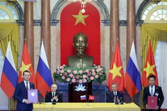 President To Lam and Russian President Putin witness the exchange of the signed cooperation agreements. (Photo: VNA)