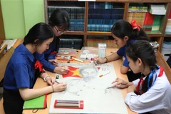 A group of students from Nguyen Du Lao-Vietnamese Bilingual School draw a picture of Uncle Ho. (Photo: VNA)