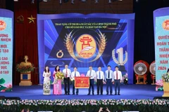 The leader of the Hanoi People's Committee presents an excellent emulation flag to the Hanoi Department of Education and Training. (Photo: VNA)