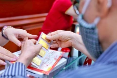 A customer buys gold at Bao Tin Minh Chau Gold's shop in Hanoi. (Photo: VNA)