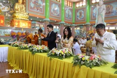 From right: Deputy Foreign Minister Le Thi Thu Hang (2nd), Vietnamese Ambassador to Thailand Pham Viet Hung (3rd), along with Buddhists monks and followers take part in the Buddha statue bathing ceremony at the celebration. (Photo: VNA) 