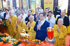 Prime Minister Pham Minh Chinh (second from the right, first row) and Vietnam Buddhist Sangha's dignitaries perform the traditional rituals of bathing the Buddha. (Photo: VNA)