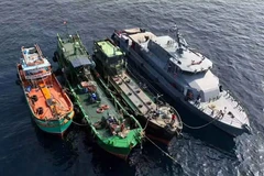 A marine police boat escorts three oil-smuggling ships which had gone missing to the Port of Songkhla early this week. (Photo: Bangkok Post) 