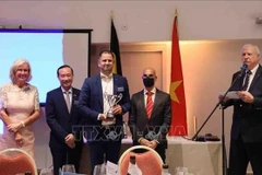 Vietnamese Ambassador to Belgium Nguyen Van Thao (second from the left) hands over the trophy to the winning golfer (Photo: VNA)