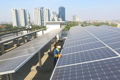 A worker inspects solar panels on top of the Energy and Mineral Resources Ministry Electricity Directorate General’s office, in Jakarta, (Photo: The Jakarta Post)