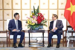 Vietnamese Prime Minister Pham Minh Chinh (right) and Chairman of the Dalian Locomotive and Rolling Stock Co. Ltd. (CRRC) Sun Rongkun at their meeting in Dalian city in China’s Liaoning province on June 24. (Photo: VNA)