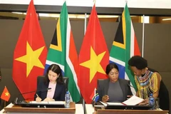 Vietnamese Deputy Foreign Minister Nguyen Minh Hang (L) and South African Deputy Minister of International Relations and Cooperation Anna Thandi Moraka sign the minutes of the 6th meeting of the Vietnam - South Africa Intergovernmental Partnership Forum in Pretoria on November 27. (Photo: VNA)
