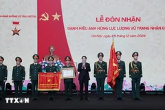 State President Luong Cuong (fourth from right) presents the title of Hero of the People's Armed Forces to the Viettel Aerospace Institute under the Viettel Military Industry and Telecoms Group (Viettel) at a ceremony on December 9 in Hanoi. (Photo: VNA)