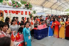 The booth of the Liaison Board of the Vietnamese Community in Singapore attracts a crowd of visitors. (Photo: VNA)