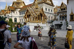 Tourists gather and take pictures in the grounds of the Grand Palace in Bangkok, Thailand. (Photo: AFP/VNA)