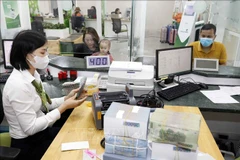 Customers make transactions at Vietcombank's branch in Vinh Phuc province. (Photo: VNA)