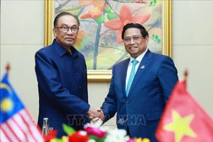 Prime Minister Pham Minh Chinh (R) and his Malaysian counterpart Anwar Ibrahim at their meeting in Vientiane on October 10. (Photo: VNA)