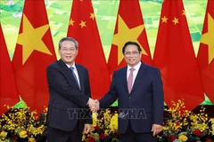 Prime Minister Pham Minh Chinh (R) shakes hands with Chinese Premier Li Qiang. (Photo: VNA)