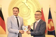 Parliamentary State Secretary of Mecklenburg-West Pomerania Patrick Dahlemann (L) presents a souvenir to Vietnamese Ambassador to Germany Vu Quang Minh (Photo: VNA)