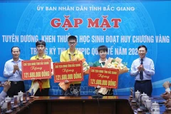 Three students who won gold medals at this year's International Olympiads receive awards at the ceremony (Photo: VNA) 