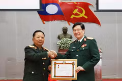 Lao Deputy Prime Minister and Minister of National Defence Gen. Chansamone Chanyalath presents a first-class Labour Order to VMMU Director Nguyen Xuan Kien. (Photo: VNA)