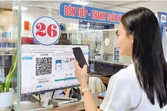 A woman pays for medical examination via QR code at a hospital in Hanoi. (Photo: nhandan.vn)