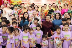 The spouse of Party General Secretary and State President of Vietnam To Lam, Ngo Phuong Ly (left, in blue dress), and the spouse of Party General Secretary and President of Laos Thongloun Sisoulith, Naly Sisoulith (right, in brown dress) join children of Birla Children's Village Hanoi in a celebration of the Mid-Autumn Festival on September 10. (Photo: VNA)