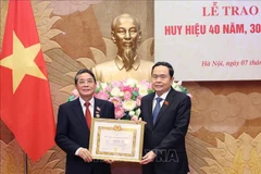 NA Chairman Tran Thanh Man (right) presents the 40-year Party membership badge to Nguyen Duc Hai, member of the Party Central Committee and Vice Chairman of the legislature, on June 7. (Photo: VNA)