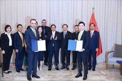 PM Pham Minh Chinh and officials witness the handover of an MoU on sports and entertainment cooperation between T&T Group and JTA International Investment Holding on October 31. (Photo: VNA)