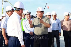 PM Pham Minh Chinh talks to officials while examining the national exhibition and fair centre project in Dong Anh district of Hanoi on October 25. (Photo: VNA)