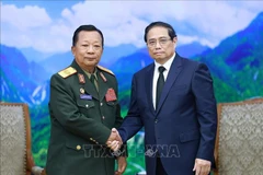 PM Pham Minh Chinh (right) receives General Chansamone Chanyalath, Deputy PM and Minister of National Defence of Laos, in Hanoi on July 25. (Photo: VNA)