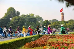 "Ao dai" wearers cycle near the Flag Tower of Hanoi. Vietnam sees the biggest improvements in diplomatic influence and cultural influence in the Asia Power Index 2024 rankings. (Photo: VNA)