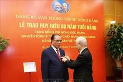 60-year Party membership badge presented to former Party chief Nong Duc Manh