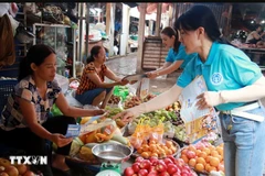 Distribute leaflets and popularise social insurance policies to people in Nam Dinh city. (Photo: VNA) 