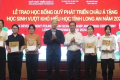 Nguyen Van Duoc, Secretary of the provincial Party Committee and Chairman of the Long An People's Council; Kim Joon Il, Chairman of COBI Group and ADF; and students at the ceremony. (Photo: VNA)
