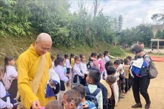 Most Venerable Thich Minh Quang and Vietnamese expatriates in Laos present relief packages to Lao residents (Photo: VNA)
