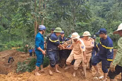 Rescuers find a victim after a mini bus is buried by a landslides in the mountainous province of Ha Giang on July 13. (Photo: VNA)