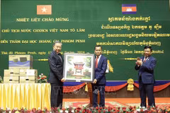 President To Lam (left) gives a gift to the Royal University of Phnom Penh. (Photo: VNA)