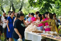 Visitors to the Vietnamese Culture Day event have some Vietnamese food. (Photo: VNA broadcasts)
