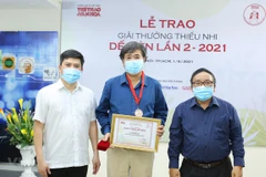 Writer Binh Ca (centre) receives a Cricket Desire award. (Photo: VNA)