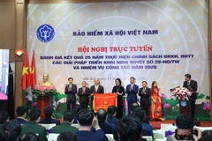 Prime Minister Nguyen Xuan Phuc presents emulation flag tothe Vietnam Social Security with the Government. (Photo: VietnamPlus)