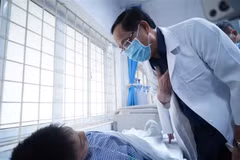 Vice Chairman of the National Assembly Tran Quang Phuong visits a fire victim at the Transport Hospital in Hanoi on May 24. (Photo: VNA)