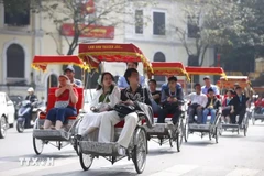 Visitors in a cyclo tour around Hoan Kiem Lake in Hanoi (Photo: VNA)