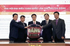 Deputy Prime Minister Vu Duc Dam (centre), VNA General Director Nguyen Duc Loi (second, left), and other delegates launch the special website on the 13th National Party Congress (Photo: VNA)
