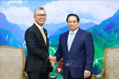 Prime Minister Pham Minh Chinh (R) and Malaysian Minister of Investment, Trade and Industry Zafrul Abdul Aziz (Photo: VNA)