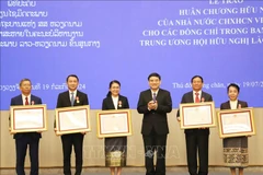 Chairman of the Vietnam-Laos Friendship Association (VLFA) Central Committee Nguyen Dac Vinh (third, right) presents the Friendship Order to 15 members of the Laos-Vietnam Friendship Association (LVFA) Central Committee (Photo: VNA)