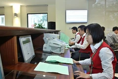 Staff at Hanoi Stock Exchange enter auction information (Photo: VNA)