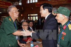 President Truong Tan Sang (R) shakes hand with a participant of the ceremony (Photo: VNA)