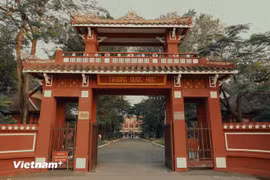 Its main gate features a two-storey traditional design, with a wooden upper level and a roof tiled with glazed imperial-yellow ceramics. To the right stands a decorative screen bearing a “dragon-horse” motif, built in the same year and still preserved today. (Photo: Vietnam+)