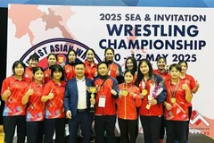 Vietnamese coaches and athletes pose with their golds and trophy from the Southeast Asian and Invitation Wrestling Championships which closed on May 12 in Singapore. (Photo: Vietnam Sports Team)