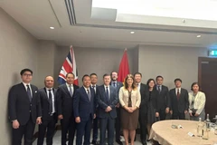 Deputy Minister Nguyen Hoang Long, Minister of State Douglas Alexander, and representatives from ministries and the embassies of both countries pose for a group photo at the 14th JETCO meeting. (Photo: VNA)