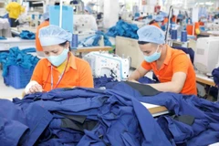 Workers make garments for export at a Viet Hung Textile Garment Company'. (Photo: VNA/VNS)